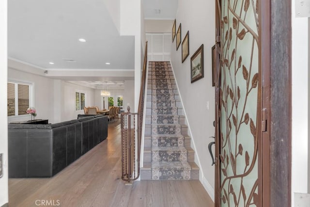 staircase featuring crown molding and hardwood / wood-style flooring