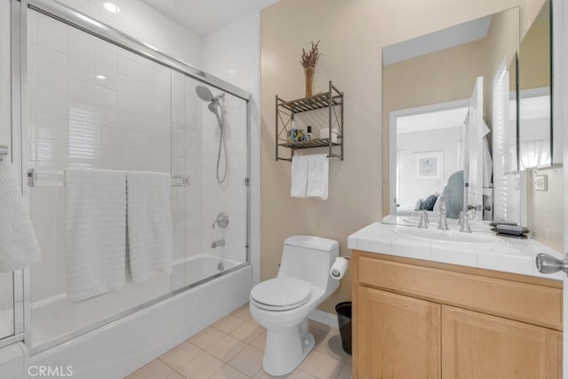 full bathroom featuring shower / bath combination with glass door, vanity, toilet, and tile patterned flooring