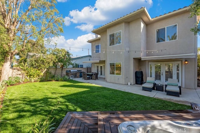 back of house with french doors, a lawn, and a patio