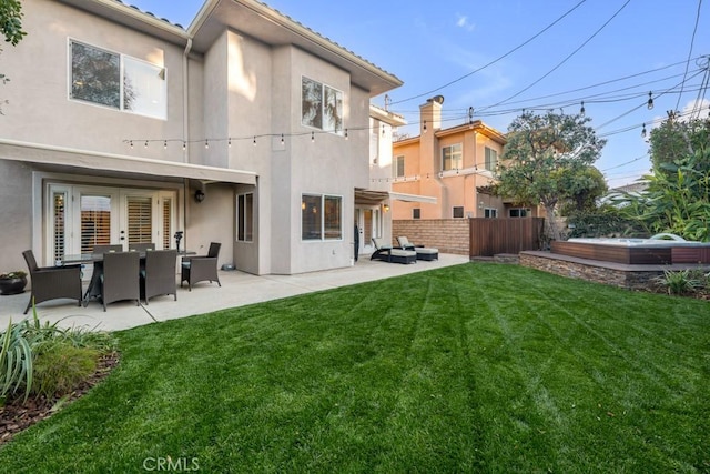 back of property featuring a lawn, french doors, and a patio