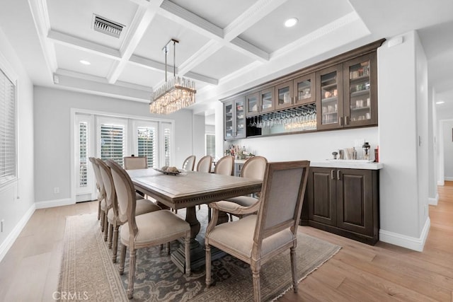 dining space with beam ceiling, french doors, coffered ceiling, and light hardwood / wood-style floors