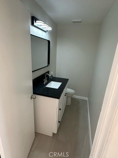 bathroom featuring toilet, vanity, and tile patterned floors