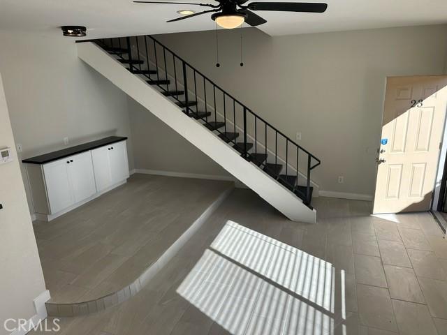 staircase with ceiling fan and hardwood / wood-style flooring