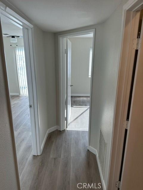 corridor with hardwood / wood-style flooring