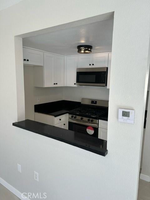 kitchen with appliances with stainless steel finishes and white cabinetry