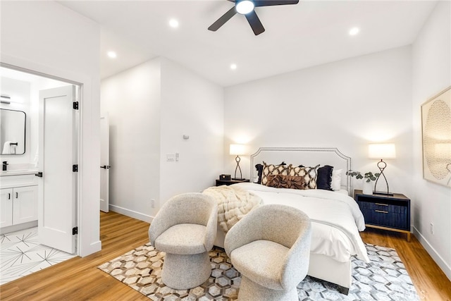 bedroom with light wood-type flooring, connected bathroom, baseboards, and recessed lighting