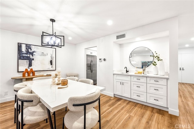 dining room with light wood-type flooring, visible vents, baseboards, and recessed lighting