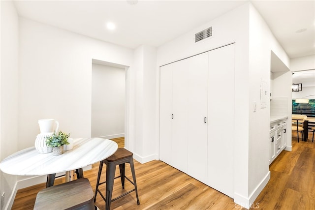 dining room featuring baseboards, visible vents, and light wood finished floors