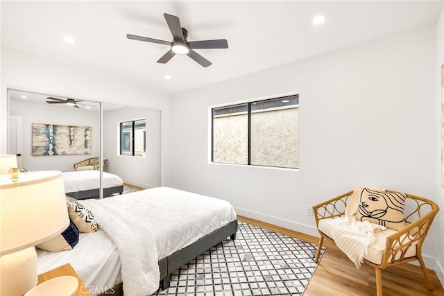 bedroom with baseboards, ceiling fan, wood finished floors, a closet, and recessed lighting