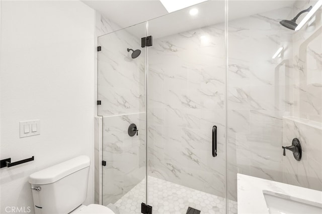 full bathroom featuring toilet and a marble finish shower