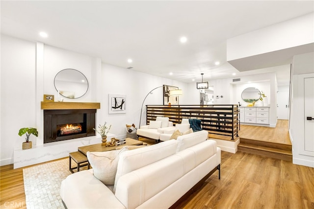 living room with light hardwood / wood-style flooring and a premium fireplace