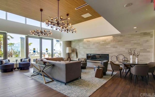 living room featuring a high ceiling, wooden ceiling, hardwood / wood-style floors, and an inviting chandelier