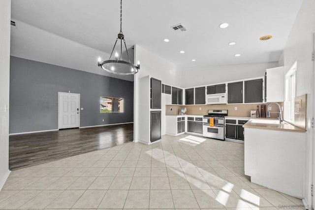 kitchen featuring light tile patterned flooring, high vaulted ceiling, sink, hanging light fixtures, and double oven range