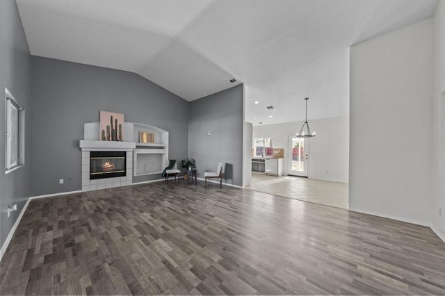 unfurnished living room with hardwood / wood-style floors and vaulted ceiling