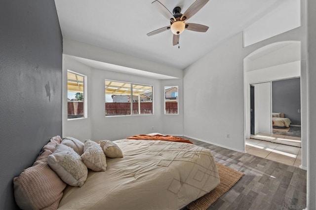 bedroom with hardwood / wood-style flooring, vaulted ceiling, and ceiling fan