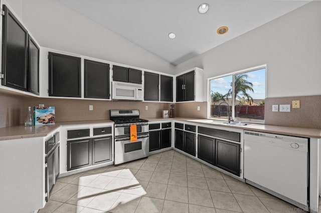 kitchen featuring sink, vaulted ceiling, light tile patterned floors, white appliances, and backsplash