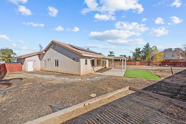 back of property featuring a patio and solar panels