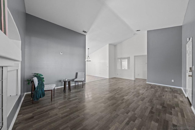 unfurnished living room with vaulted ceiling and dark hardwood / wood-style flooring