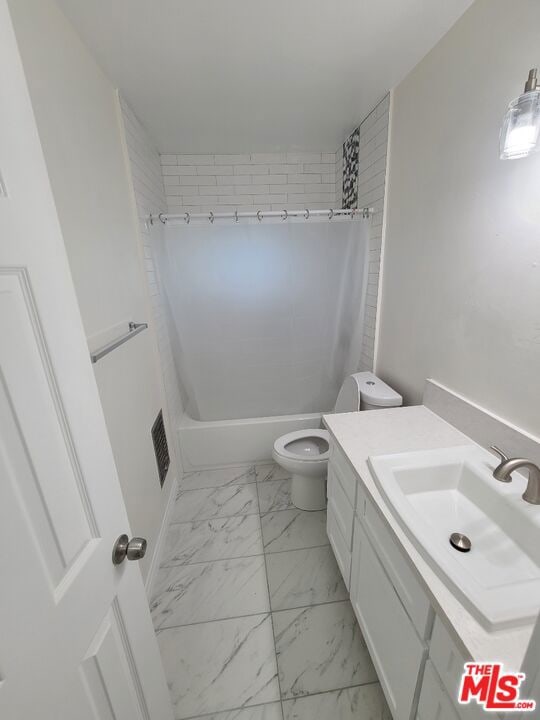 full bathroom with toilet, vanity, and shower / tub combo with curtain