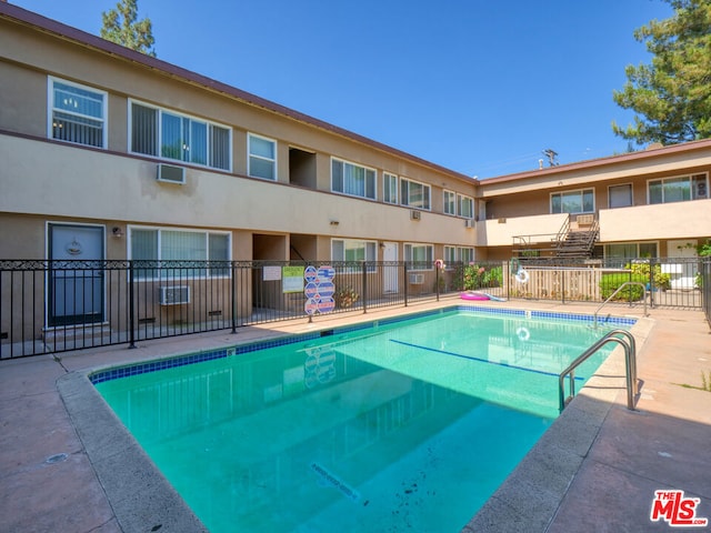 view of swimming pool with a wall unit AC