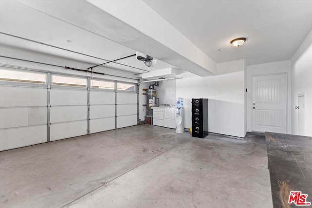 garage featuring washer and dryer, secured water heater, and a garage door opener