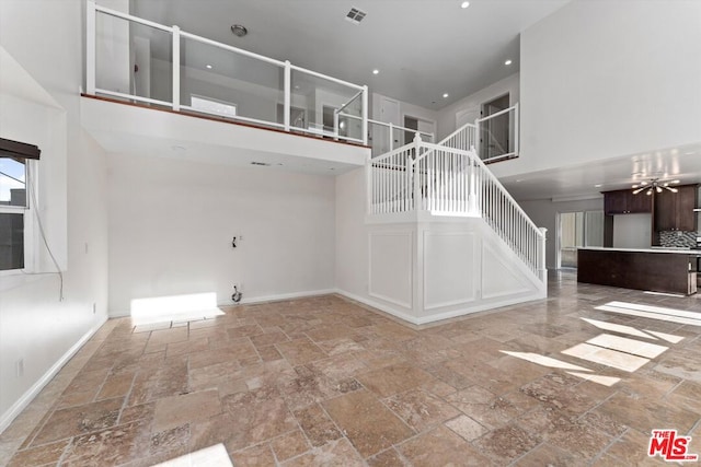 unfurnished living room with a high ceiling