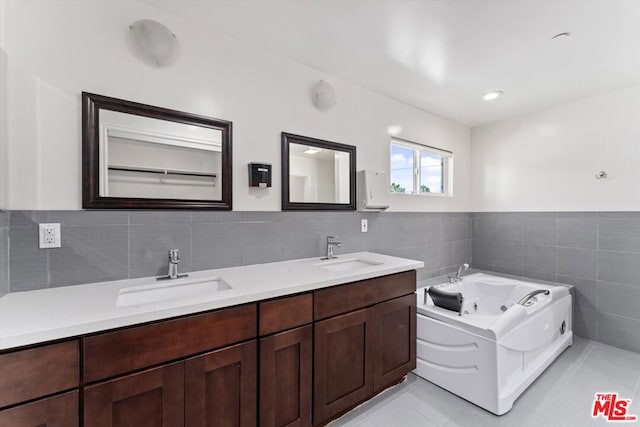 bathroom with a bath, tile walls, tile patterned floors, and vanity