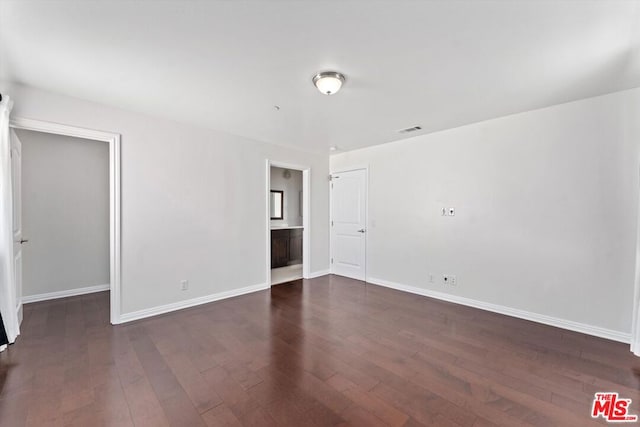 unfurnished room with dark wood-type flooring