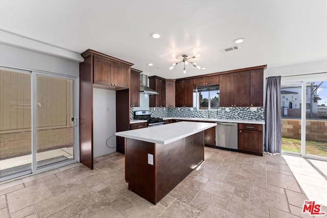 kitchen with a center island, wall chimney exhaust hood, stainless steel appliances, decorative backsplash, and dark brown cabinets