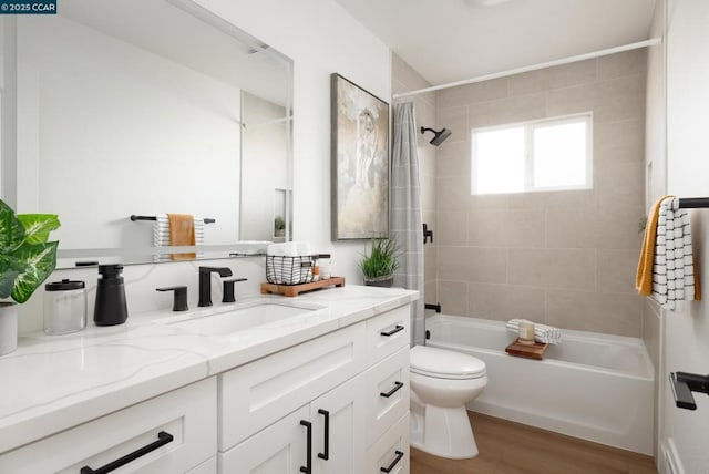 full bathroom featuring wood-type flooring, toilet, vanity, and tiled shower / bath