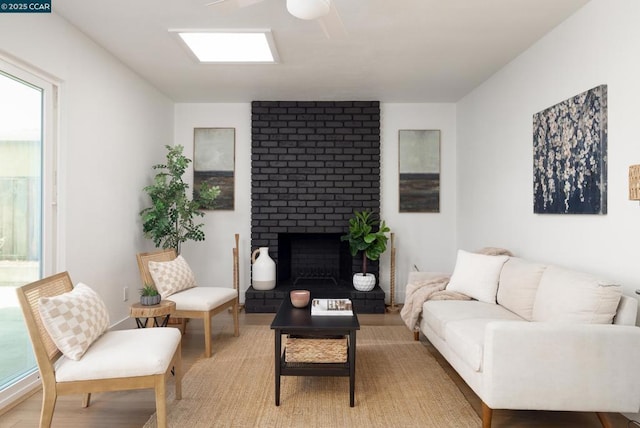 living room featuring a brick fireplace, a wealth of natural light, and ceiling fan