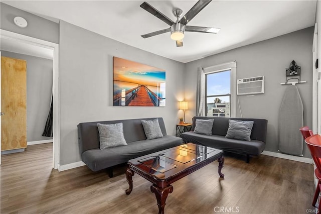 living room featuring ceiling fan, dark hardwood / wood-style flooring, and an AC wall unit