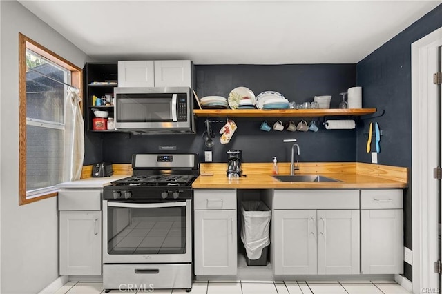 kitchen with appliances with stainless steel finishes, white cabinets, and sink