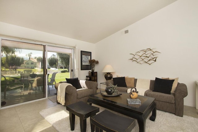 living room with light tile patterned floors and vaulted ceiling