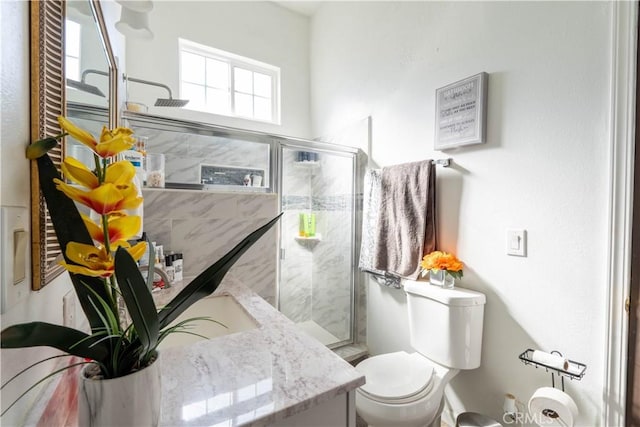 bathroom with vanity, toilet, and a shower with door