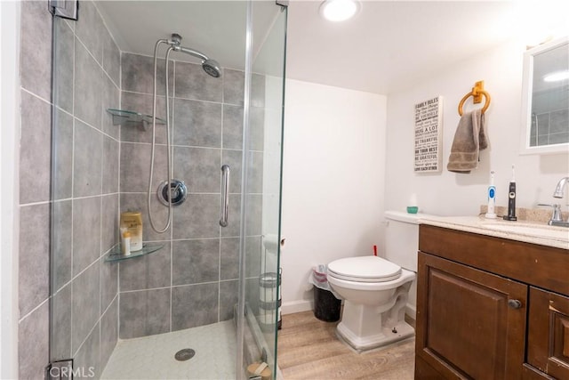 bathroom with walk in shower, vanity, wood-type flooring, and toilet