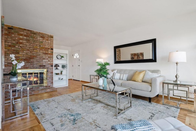 living room featuring built in features, a brick fireplace, and light parquet floors