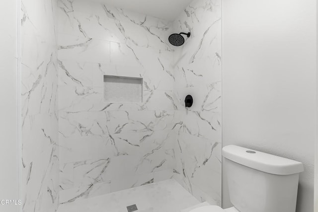 bathroom featuring toilet and tiled shower