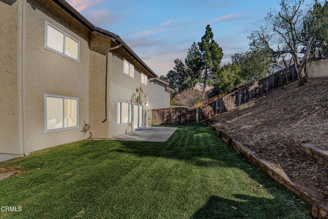 yard at dusk featuring a patio