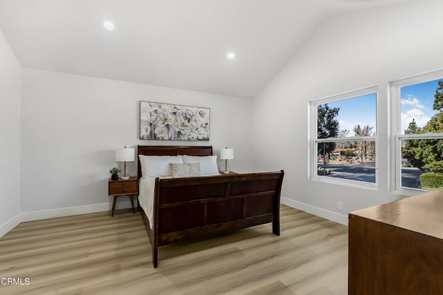 bedroom featuring light hardwood / wood-style floors and high vaulted ceiling