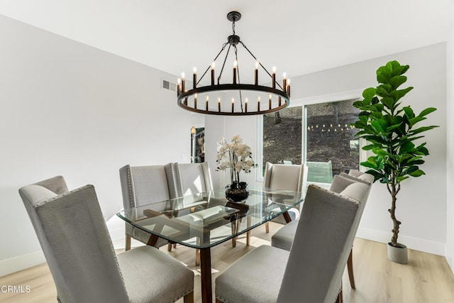 dining space featuring an inviting chandelier and light hardwood / wood-style floors