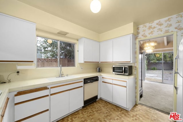 kitchen with tile countertops, decorative light fixtures, white appliances, white cabinets, and sink