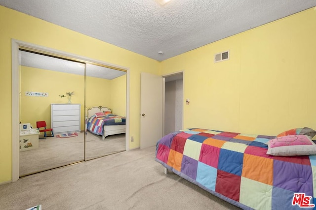 bedroom featuring carpet floors, a textured ceiling, and a closet