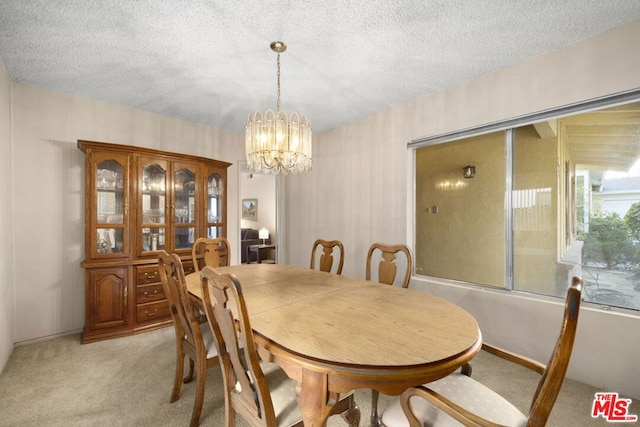 carpeted dining room with a textured ceiling and a chandelier