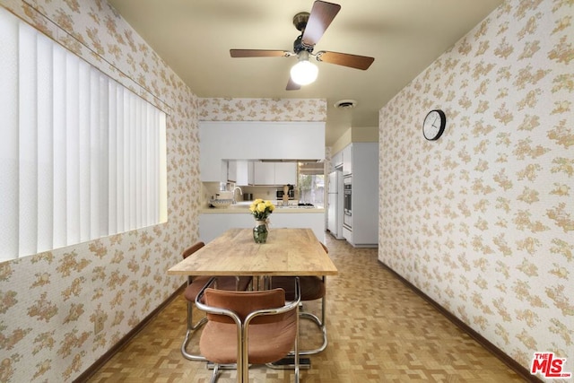 dining room featuring ceiling fan, sink, and light parquet floors