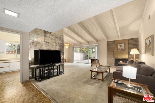 carpeted living room with sink, a fireplace, plenty of natural light, and lofted ceiling with beams