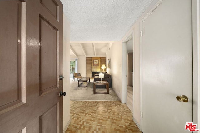 hall featuring beam ceiling and a textured ceiling