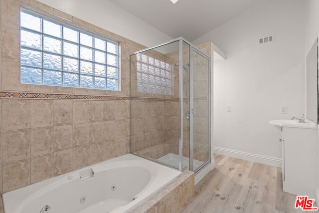 bathroom with independent shower and bath, hardwood / wood-style flooring, and vanity