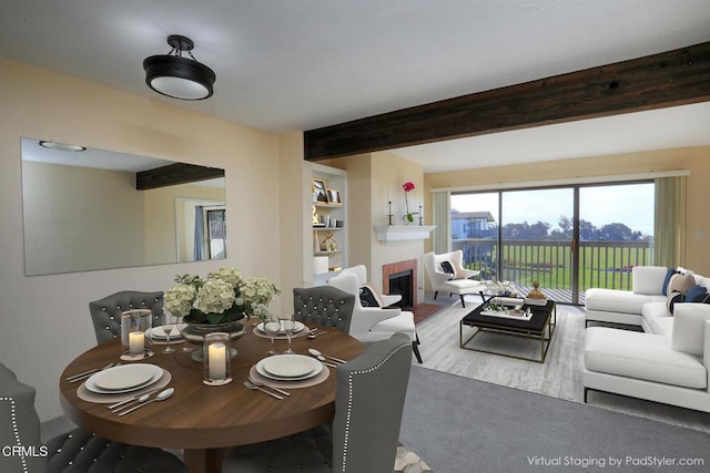 dining space with a fireplace and beam ceiling