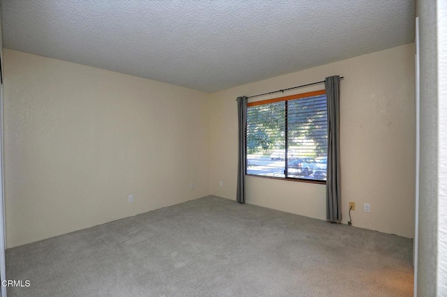 carpeted empty room with a textured ceiling